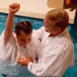 Person being baptized in pool by pastor