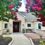 Home entrance framed by pink flowering trees